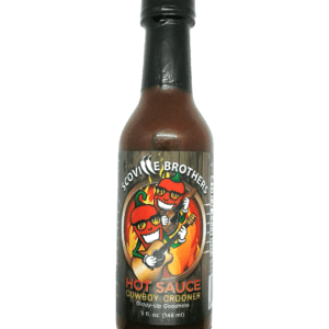 A bottle of hot sauce with a green background